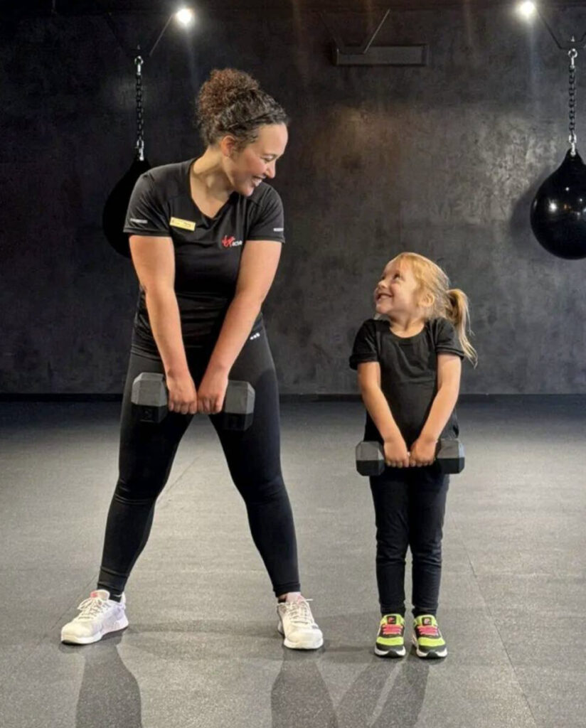 Marcia, a personal trainer at Virgin Active The Sanctuary, working out with her favorite client holding dumbbells in an indoor gym, staying fit during Somerset West's winter months.