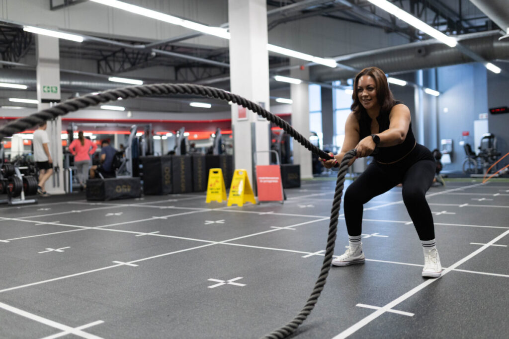 A determined client performing a vigorous battle rope workout at Virgin Active The Sanctuary in Somerset West, boosting heart health and cardiovascular fitness with dynamic cardio exercise.