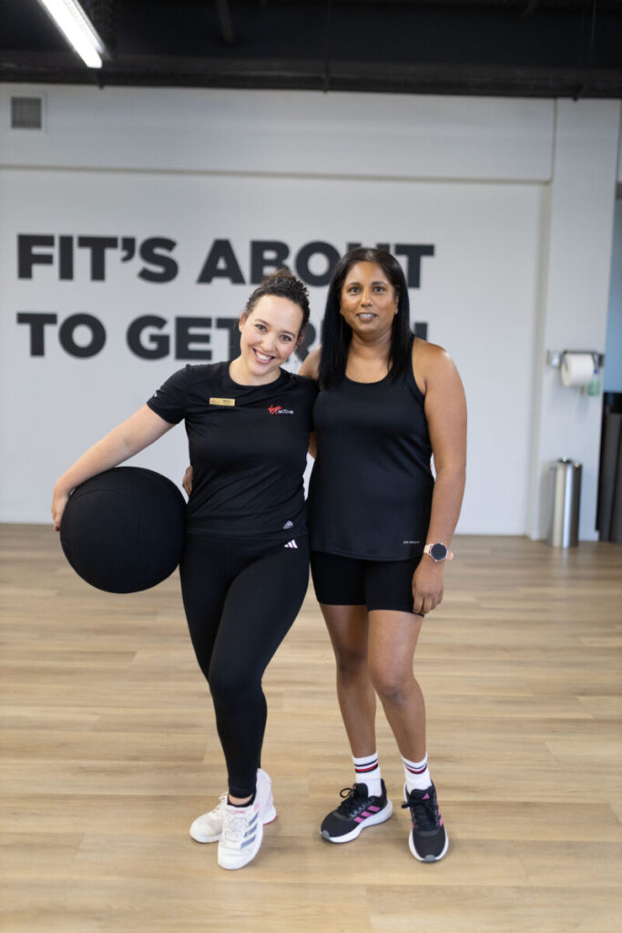 Marcia Swanepoel posing with a client at Virgin Active The Sanctuary in Somerset West, holding a medicine ball and smiling, ready to embark on a fitness journey to improve heart health and overall well-being.