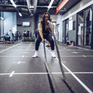 Marcia Swanepoel, a personal trainer at Virgin Active The Sanctuary in Somerset West, assisting a client with an energetic battle rope exercise, enhancing cardiovascular fitness and strength for overall health